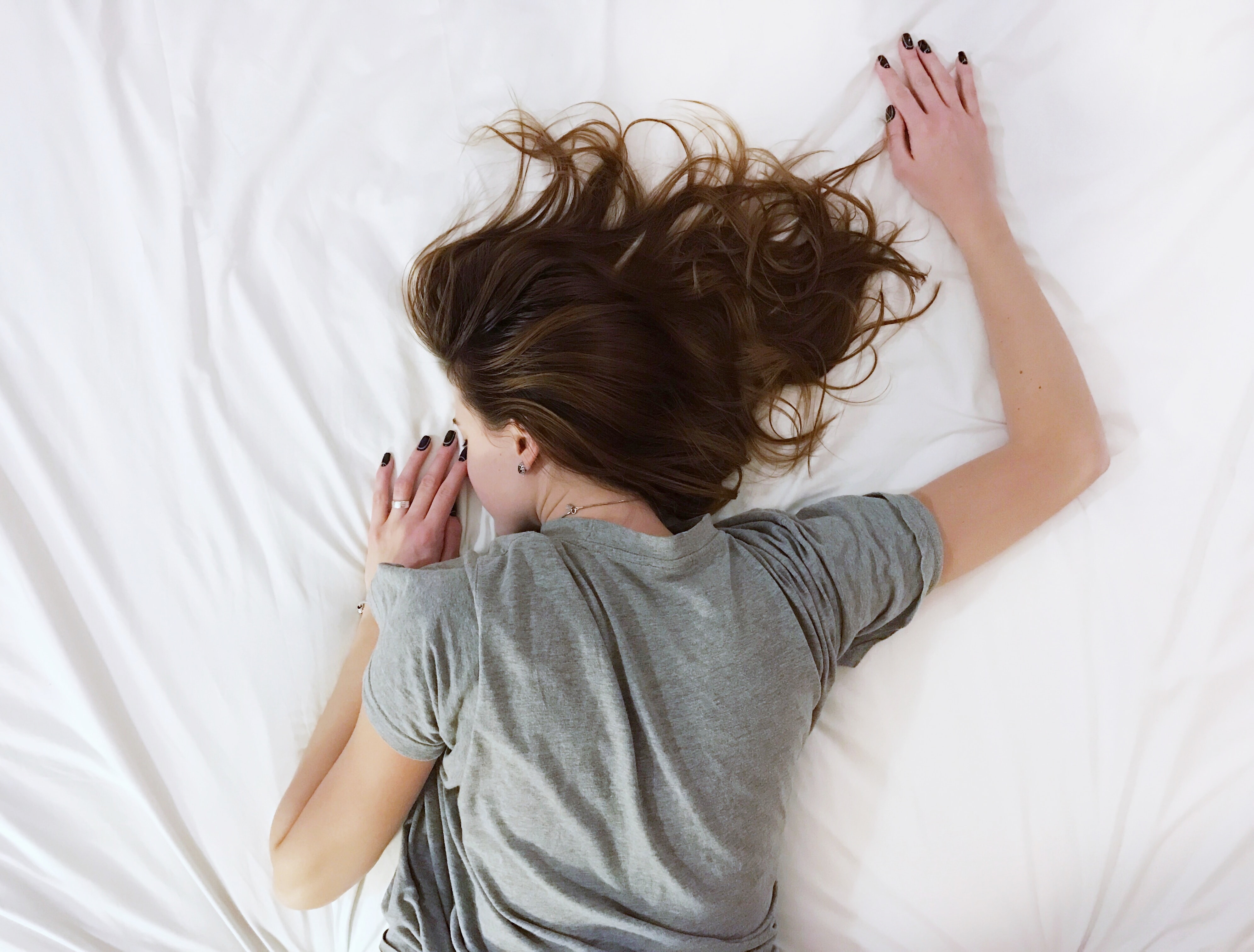 Woman sleeps on white sheets